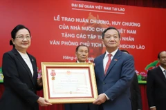 Chủ nhiệm Văn phòng Chủ tịch nước Lào Khemmani Phonsena nhận Huân chương Độc lập hạng Nhất của Đảng, Nhà nước Việt Nam trao tặng. (Ảnh: Xuân Tú/TTXVN)