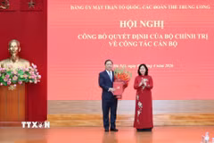 Đồng chí Bùi Thị Minh Hoài, Ủy viên Bộ Chính trị, Bí thư Trung ương Đảng, Bí thư Đảng ủy Mặt trận Tổ quốc, các đoàn thể Trung ương, Chủ tịch Ủy ban Trung ương Mặt trận Tổ quốc Việt Nam, trao quyết định cho đồng chí Nguyễn Phi Long. (Ảnh: TTXVN phát)