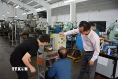 Hướng dẫn sinh viên chế tạo sản phẩm khoa học. (Ảnh: Văn Dũng/TTXVN)