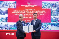 Ông Watanabe Hiroyuki - Chủ tịch Quỹ Câu lạc bộ Aeon 1% - trao khoản hỗ trợ 50.000 USD hỗ trợ người dân Việt Nam khắc phục hậu quả bão lũ. (Ảnh: Xuân Giao/TTXVN)