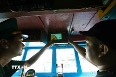 Bộ đội Biên phòng kiểm tra thiết bị giám sát hành trình khai thác thuỷ sản trên tàu cá trước khi ra khơi. (Ảnh: Vũ Sinh/TTXVN)