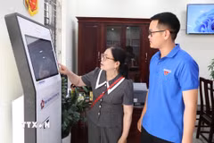 Đoàn viên thanh niên hướng dẫn người dân sử dụng dịch vụ công trực tuyến tại Trung tâm Phục vụ hành chính công xã Giao Bình, tỉnh Ninh Bình. (Ảnh: Thùy Dung/TTXVN)