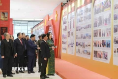 Thường trực Ban Bí thư Trần Cẩm Tú tham quan khu trưng bày ảnh “Dưới cờ Đảng - đất nước tiến vào kỷ nguyên mới” do TTXVN thực hiện. (Ảnh: Phương Hoa/TTXVN)