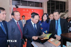 Trưởng Ban Tuyên giáo và Dân vận Trung ương Trịnh Văn Quyết cùng các đại biểu tham quan khu trưng bày sách đoạt giải. (Ảnh: Phan Phương/TTXVN)