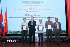 Trung tướng Nguyễn Văn Nam (thứ 2, từ trái sang), Chủ tịch Hội hữu nghị Việt Nam-Campuchia Thành phố Hồ Chí Minh, trao quyết định kiện toàn Chi hội trực thuộc Hội. (Ảnh: Xuân Khu/TTXVN)