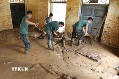 Lực lượng quân đội thu dọn bùn đất tại điểm trường mầm non Suối Lư, Điện Biên. (Ảnh: Trung Kiên/TTXVN)