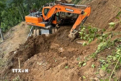 Các đơn vị tăng cường phương tiện máy công trình để khẩn trương thông tuyến. (Ảnh: TTXVN phát)
