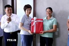Tổng Giám đốc TTXVN Vũ Việt Trang tặng quà cho gia đình được TTXVN hỗ trợ xây dựng nhà mới. (Ảnh: Quang Cường/TTXVN)
