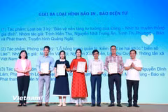 Đại diện nhóm tác giả TTXVN (thứ 2 bên trái) nhận giải. (Ảnh: PV/Vietnam+)