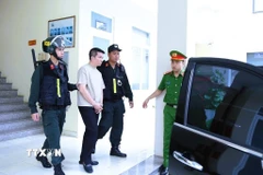 Dẫn giải bị can Nguyễn Quốc Vũ. (Ảnh: TTXVN phát)