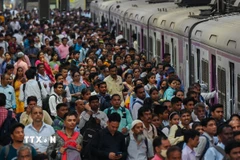 Người dân chen lấn chờ lên tàu hỏa tại nhà ga ở Mumbai, Ấn Độ. (Ảnh: AFP/TTXVN)