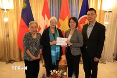 Đại sứ quán Việt Nam tại Thụy Sĩ nhận số tiền ủng hộ từ các tổ chức. (Ảnh: Anh Hiển/TTXVN)