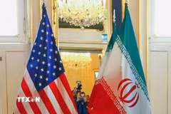 Quốc kỳ Mỹ (trái) và Iran tại một bàn đàm phán. (Ảnh: MNA/TTXVN)