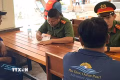 Cơ quan điều tra làm việc với các thuyền viên có liên quan đến vụ chìm canô tại Phú Quốc. (Ảnh: TTXVN phát)