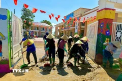 Giáo viên và đoàn viên thanh niên dọn dẹp sau lũ tại trường Mầm non Liên Minh, Hà Tĩnh. (Ảnh: TTXVN phát)