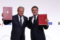 Tổng thống Pháp Emmanuel Macron (phải) và Thủ tướng Ba Lan Donald Tusk ký hiệp ước hợp tác và hữu nghị mới. (Nguồn: Bankier.pl)