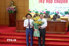 Ông Nguyễn Mạnh Hùng, Phó Bí thư Tỉnh ủy, Chủ tịch Hội đồng Nhân dân tỉnh Tây Ninh tặng hoa chúc mừng tân Chủ tịch Ủy ban Nhân dân tỉnh Tây Ninh Lê Văn Hẳn. (Ảnh: Bùi Giang/TTXVN)