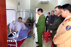 Đại tá Ma Quang Trung, Phó Giám đốc Công an tỉnh Tuyên Quang, thăm hỏi, động viên Thiếu tá Nguyễn Văn Đông, cán bộ Cảnh sát giao thông bị thương khi làm nhiệm vụ, đang điều trị tại Trung tâm y tế khu vực Hàm Yên. (Ảnh: TTXVN phát)