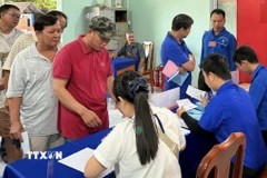 Đoàn viên, thanh niên phường Chơn Thành, tỉnh Đồng Nai hỗ trợ cử tri, hướng dẫn quy trình bầu cử, góp phần bảo đảm ngày bầu cử diễn ra thuận lợi, an toàn và đúng quy định. (Ảnh: Nhật Bình/TTXVN)
