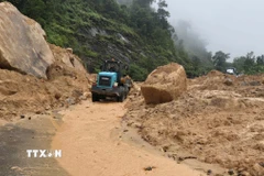 Công ty cổ phần Quản lý và Xây dựng giao thông Khánh Hòa đang khắc phục sự cố sạt lở đèo. (Ảnh: Xuân Triệu/TTXVN)
