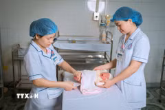 Các y bác sỹ của Trung tâm y tế khu vực Hữu Lũng kiểm tra cho trẻ sơ sinh. (Ảnh: Tiến Vĩnh/TTXVN)