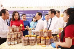 Lãnh đạo tỉnh Đồng Nai tham quan gian hàng đặc sản hạt điều rang muối của địa phương. (Ảnh: Nhật Bình/TTXVN)