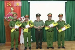 Đại tá Lâm Phước Nguyên, Giám đốc Công an tỉnh An Giang trao thưởng nóng Chủ tịch UBND tỉnh An Giang cho 4 tập thể. (Ảnh: TTXVN phát)