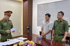 Cơ quan công an tống đạt quyết định khởi tố bị can, lệnh bắt tạm giam tài xế Thanh. (Ảnh: TTXVN phát)
