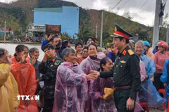Bộ trưởng Bộ Quốc phòng Đại tướng Phan Văn Giang thăm hỏi người dân vùng lũ ở xã Tuy Phước. (Ảnh: Sỹ Thắng/TTXVN)