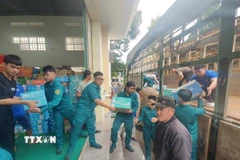 Lực lượng quân đội và nhân dân các xã phía Tây tỉnh Gia Lai sắp xếp hàng hóa gửi về cứu trợ đồng bào lũ lụt. (Ảnh: Hồng Điệp/TTXVN)