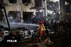 Lực lượng an ninh và cứu hộ Israel làm nhiệm vụ tại hiện trường đổ nát do trúng tên lửa phóng từ Iran tại Tel Aviv, Israel. (Ảnh: THX/TTXVN)
