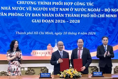 Đại diện Ủy ban về người Việt Nam ở nước ngoài và Văn phòng Ủy ban Nhân dân Thành phố Hồ Chí Minh trao đổi văn kiện ký kết. (Ảnh: Liên Sơn/TTXVN)