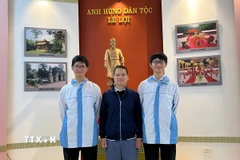 Thầy giáo Bùi Văn Bình, giáo viên môn Toán Trường THPT chuyên Lam Sơn chụp ảnh cùng Phúc Khánh (bên trái) và Vĩnh Kỳ. (Ảnh: TTXVN phát)