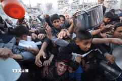 Người dân chờ được phát thực phẩm cứu trợ tại Gaza. (Ảnh: THX/TTXVN)