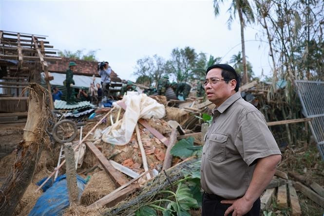 Thủ tướng Phạm Minh Chính thăm hộ gia đình có nhà bị sập hoàn toàn tại thôn Phú Hữu, xã Hòa Thịnh. (Ảnh: Dương Giang/TTXVN)