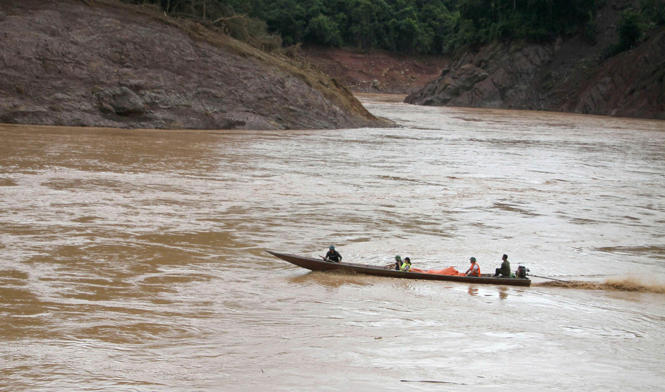 Các đoàn thiện nguyện cùng các đơn vị vận chuyển hàng cứu trợ qua sông Lam đến với người dân bản Lau, xã Tương Dương. (Ảnh: Văn Tý/TTXVN)