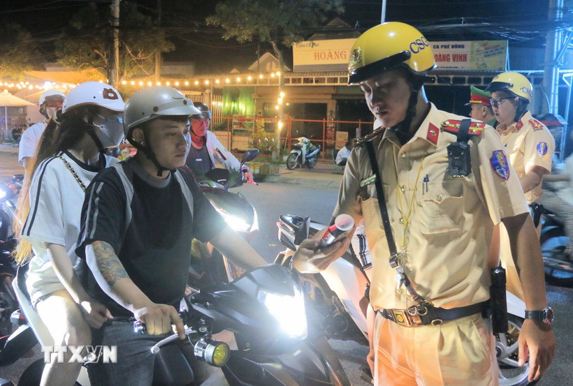 Kiểm tra nồng độ cồn đối với người điều khiển xe máy. (Ảnh: Công Mạo/TTXVN)