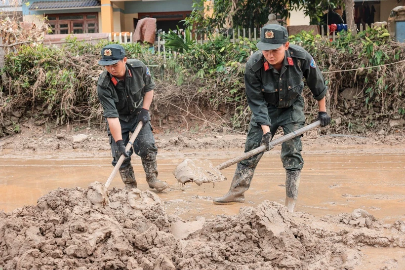 Cảnh sát cơ động hỗ trợ giúp dọn dẹp đường sá, giúp giao thông huyện Bảo Yên, tỉnh Lào Cai thông suốt, an toàn. (Ảnh: Hoàng Hiếu/TTXVN)