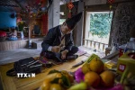Thầy Mo của vùng Mường Thàng huyện Cao Phong làm lễ trước bàn thờ tổ tiên xin phép thần linh, thổ công thổ địa để mời ông bà tổ tiên về ăn Tết cùng con cháu. (Ảnh Trọng Đạt/TTXVN)