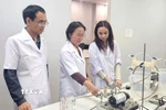 Giáo sư-Tiến sỹ Trần Thị Việt Nga, Viện trưởng Viện Công nghệ cao Việt Nhật, Giảng viên cao cấp Khoa Kỹ thuật Môi trường, Trường Đại học Xây dựng Hà Nội (đứng giữa) đang hướng dẫn các nghiên cứu sinh. (Ảnh: TTXVN phát)