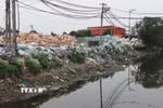 Rác thải nhựa của thôn Minh Khai được tập kết ngay cạnh bờ sông, gây ô nhiễm nghiêm trọng môi trường nguồn nước. (Ảnh: Mạnh Khánh/TTXVN)