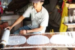 Anh Nguyễn Văn Tài ở ấp Hậu Thuận, xã Hậu Thành, huyện Cái Bè, tỉnh Tiền Giang đặt bánh vừa tráng vào vỉ để phơi khô. (Ảnh: Hữu Chí/TTXVN)