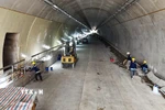 Công nhân và các phương tiện, máy móc thi công các hạng mục bên trong ống hầm. (Ảnh: Hữu Quyết/TTXVN)