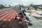 Lũ dâng cao, người dân phải phá mái nhà leo lên để tránh nguy hiểm ở Gia Lai. (Ảnh: TTXVN phát)