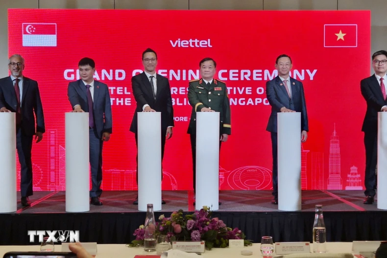 Thượng tướng Hoàng Xuân Chiến (thứ 3 phải sang), Ủy viên Thường vụ Quân ủy Trung ương, Thứ trưởng Bộ Quốc phòng cùng các đại biểu bấm nút khai trương Văn phòng Đại diện Viettel tại Singapore. (Ảnh: Việt Dũng/TTXVN)