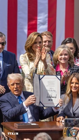 Tổng thống Mỹ Donald Trump ký ban hành Đạo luật "Gỡ bỏ," tại Nhà Trắng, Washington, D.C. ngày 19/5/2025, với sự có mặt của Đệ nhất Phu nhân Melania Trump - người đã tích cực vận động Quốc hội thông qua đạo luật này. (Ảnh: THX/TTXVN)