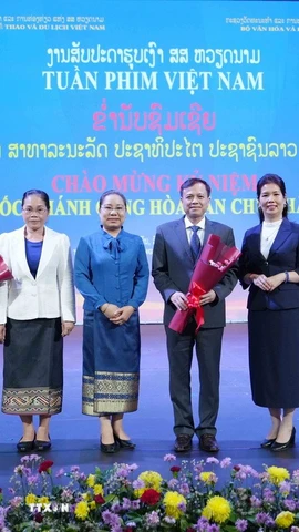 Các đại biểu Việt Nam-Lào chụp ảnh chung tại Lễ bế mạc Tuần phim Việt Nam tại Thủ đô Vientiane. (Ảnh: Đỗ Bá Thành/TTXVN)