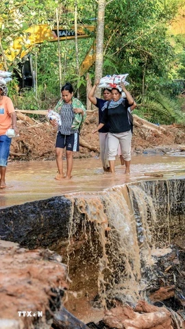 Người dân tại vùng bị ảnh hưởng bởi lũ lụt ở Bắc Sumatra (Indonesia), nhận hàng cứu trợ ngày 2/12/2025. (Ảnh: THX/TTXVN)