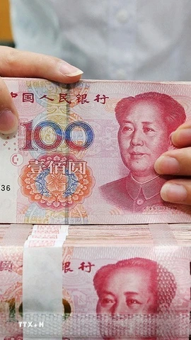 Kiểm tiền mệnh giá 100 nhân dân tệ tại một ngân hàng ở Nam Thông, tỉnh Giang Tô (Trung Quốc). (Ảnh: THX/TTXVN)