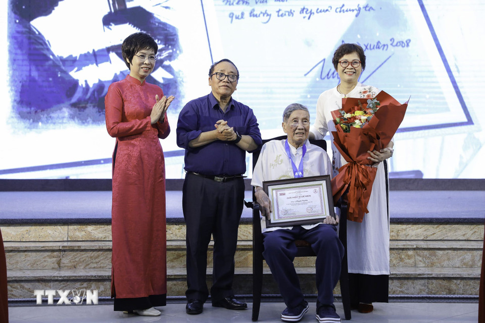 Tổng Giám đốc TTXVN Vũ Việt Trang và Phó Chủ tịch Hội Nhà văn Việt Nam, Chủ tịch Hội đồng giám khảo Trần Đăng Khoa trao giải "Hiệp sĩ Dế Mèn" cho nhạc sỹ Phạm Tuyên. (Ảnh: Lê Đông/TTXVN)